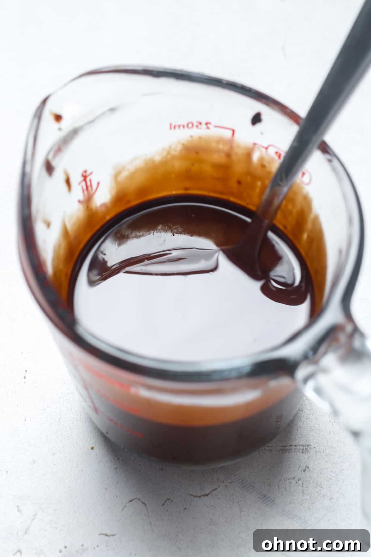 Perfectly melted chocolate and coconut oil mixture in a glass bowl, smooth and ready for the next step.
