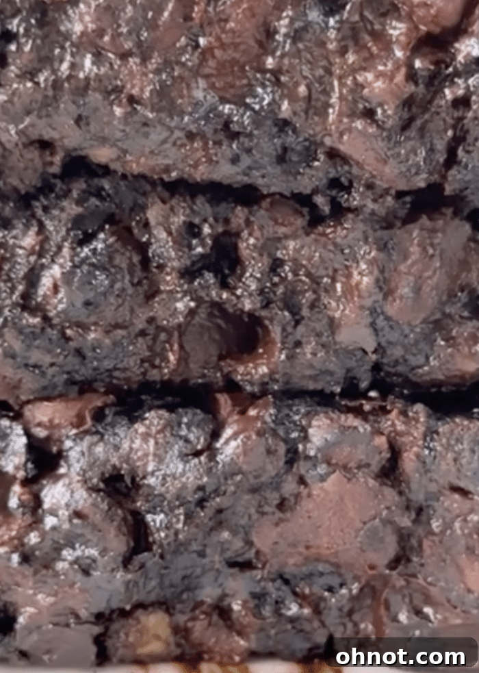 Fudgy gooey brownies stacked on a plate.