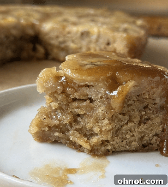 A close-up of a delicious slice of banana upside down cake showing the perfect caramelized topping and moist crumb.