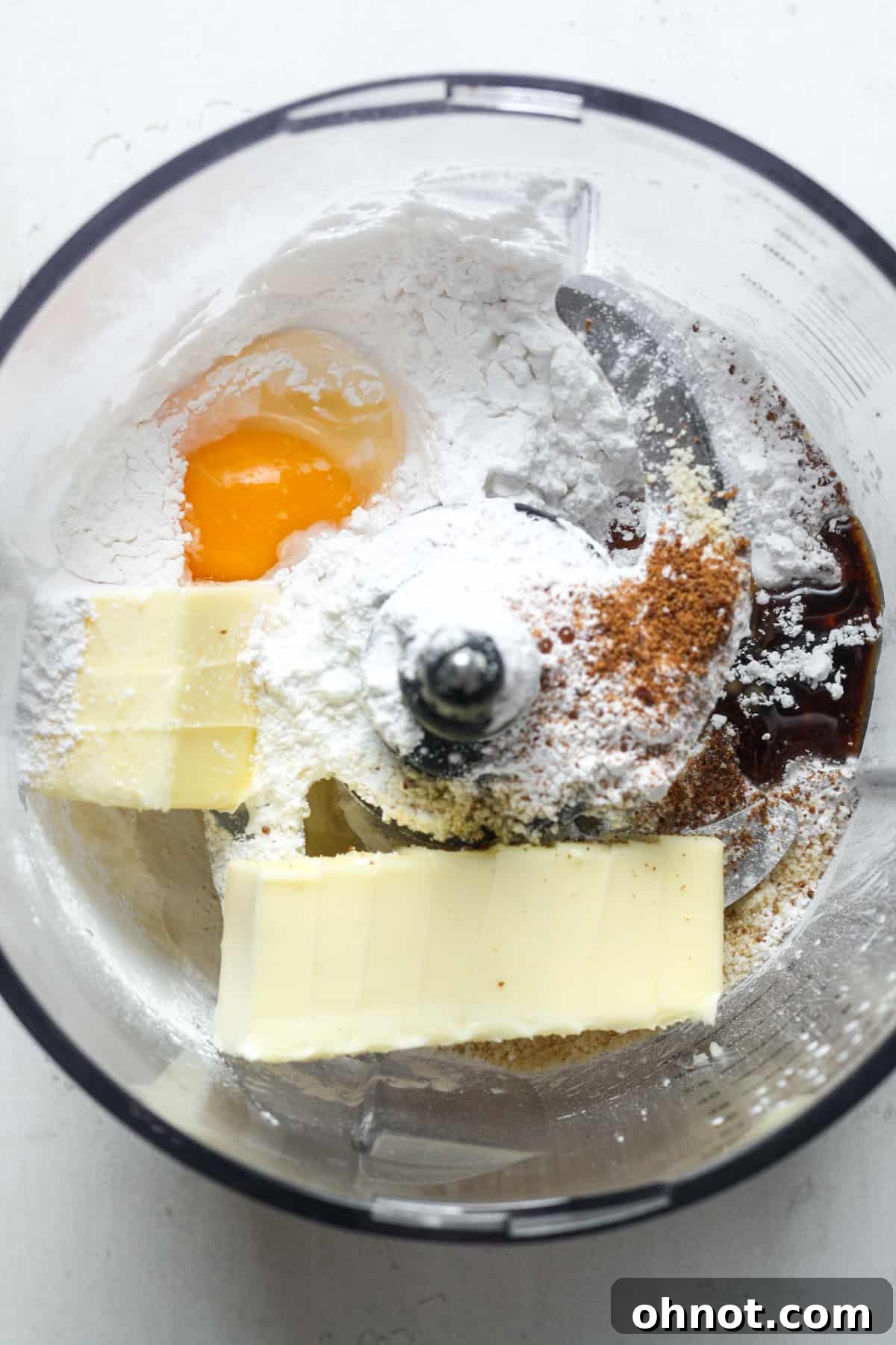 Cold butter, egg, and flours combined in a food processor, ready to be pulsed.