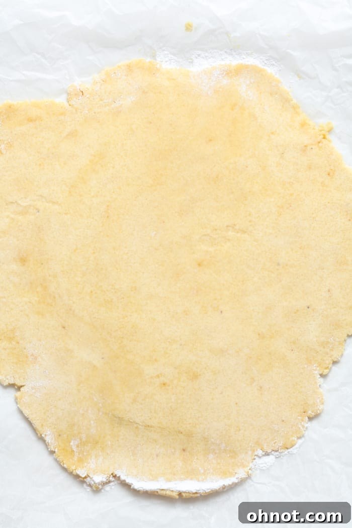 The Paleo pie crust dough expertly rolled out into a perfect circle on parchment paper.