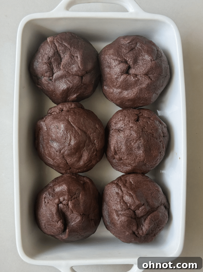 Balls of chocolate dough ready for baking, each with a hidden chocolate core.