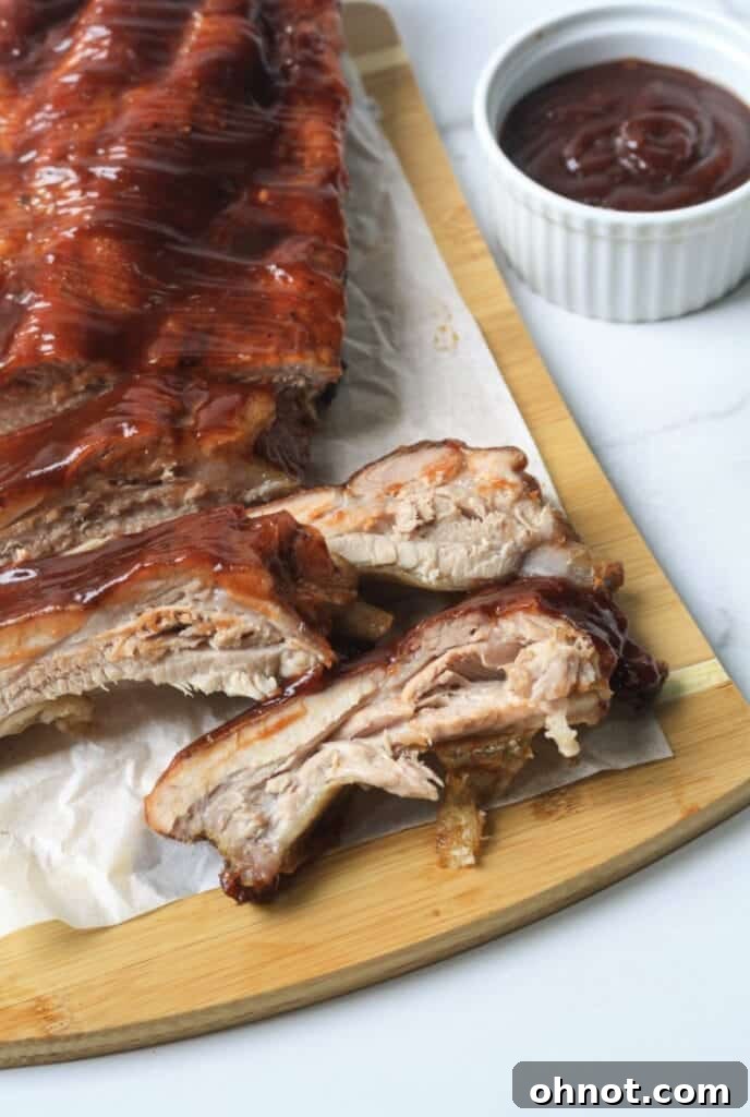 A full rack of perfectly cooked Paleo BBQ ribs, showing off the caramelized BBQ sauce.