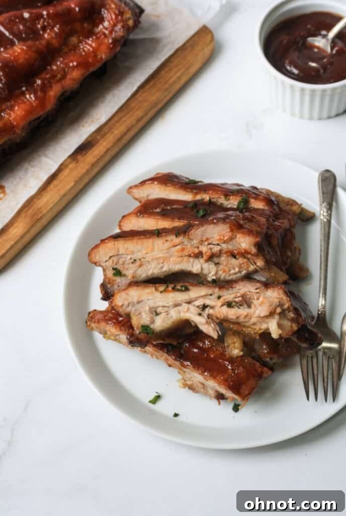 Individual Whole30 ribs with BBQ sauce on a clean white plate, garnished for serving.
