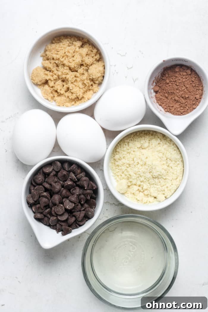 A collection of ingredients laid out for making gluten free lava cakes, including chocolate chips, eggs, and almond flour.