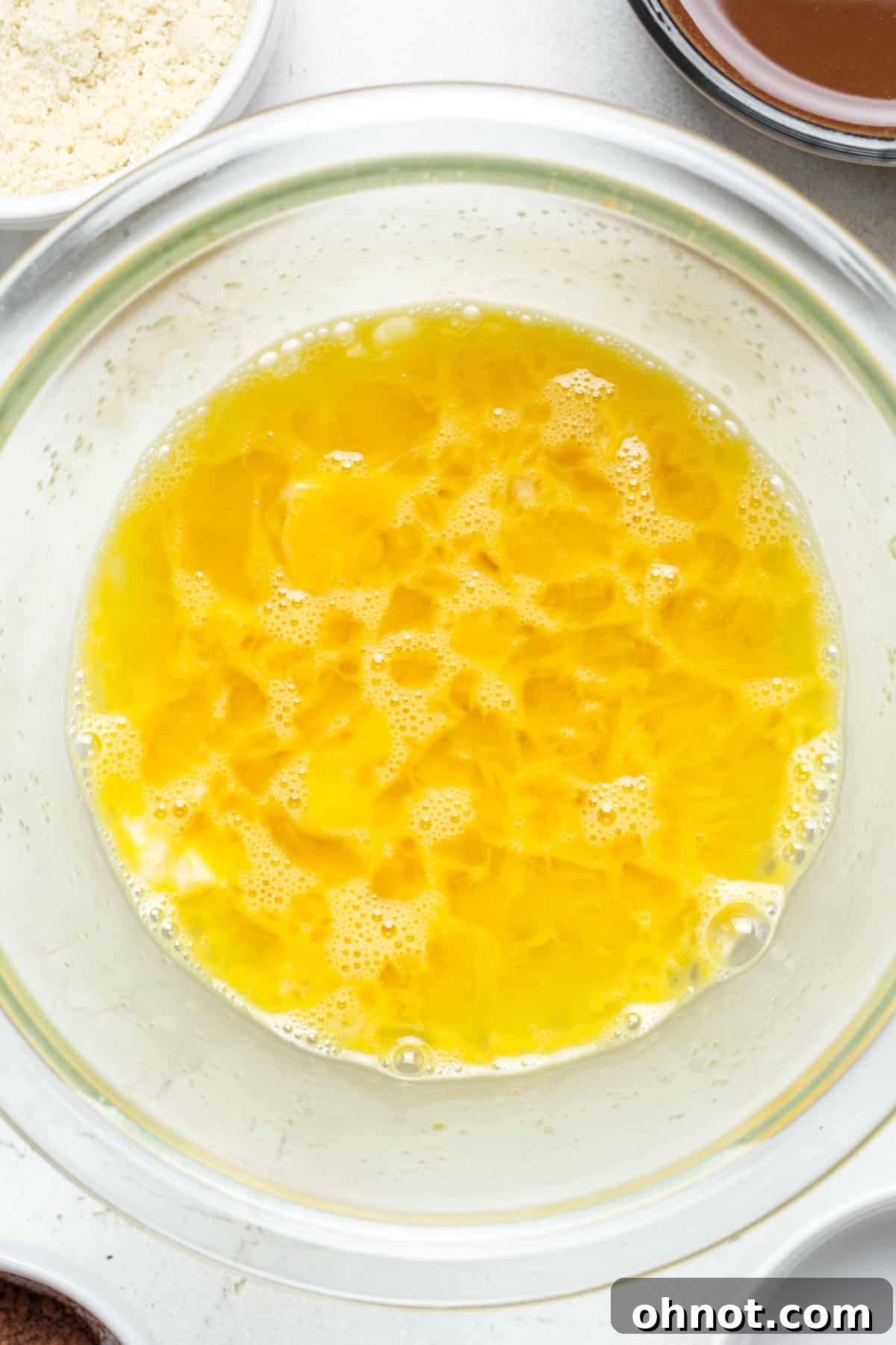 Whisked eggs and coconut sugar in a mixing bowl, light and frothy.