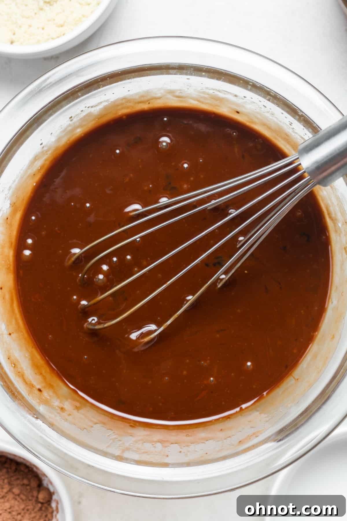A smooth, dark chocolate batter after combining melted chocolate with eggs and sugar.