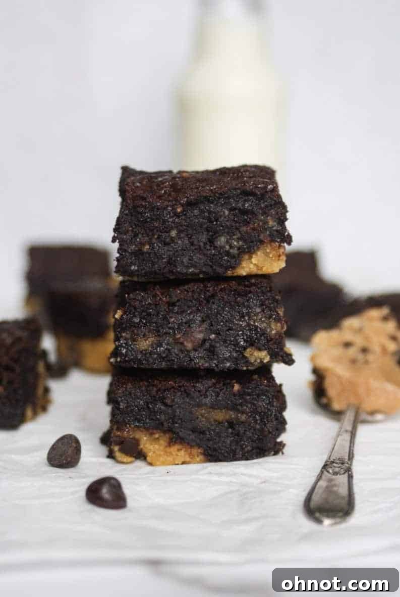 A stack of three grain-free cookie dough stuffed brownies on a white plate, showcasing their thick layers and delicious appeal