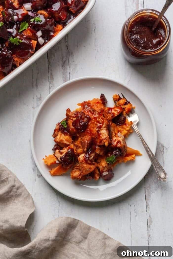 A close-up of Whole30 BBQ Chicken Casserole on a white plate, showcasing the layers.