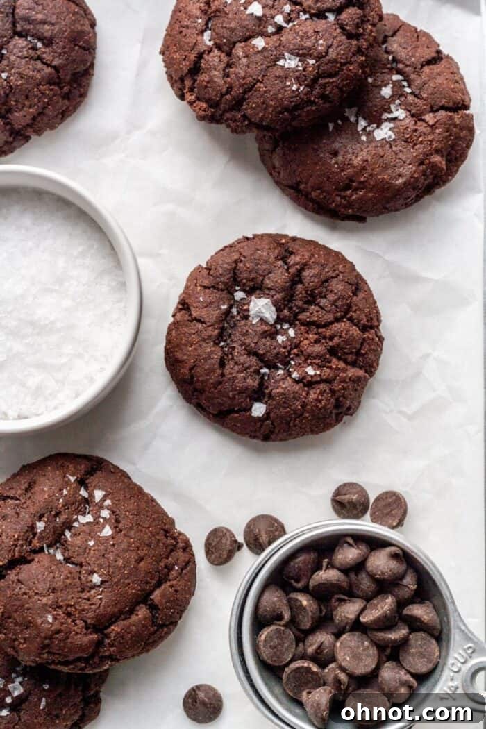 Paleo Brownie cookies on parchment paper, fresh from the oven, showing their perfect round shape and crinkled tops.