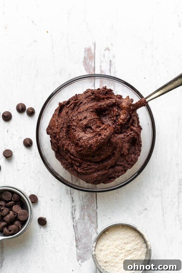 Thick, dark brownie cookie batter dough in a mixing bowl, ready for scooping.