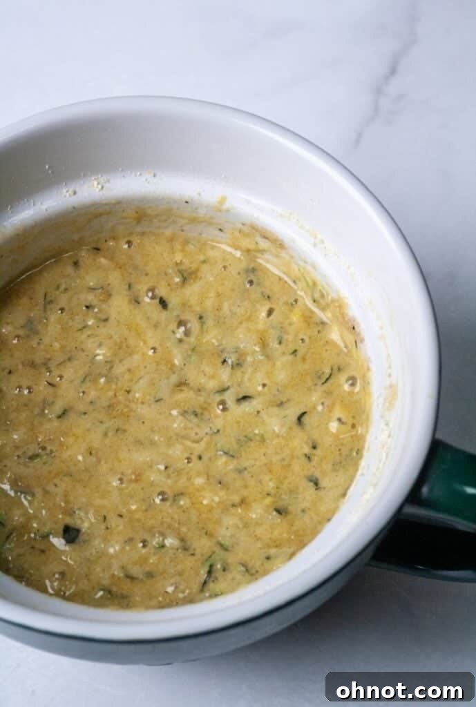 Paleo Zucchini Muffin batter in a mixing bowl, showcasing its thick, moist texture before chocolate chips are added.