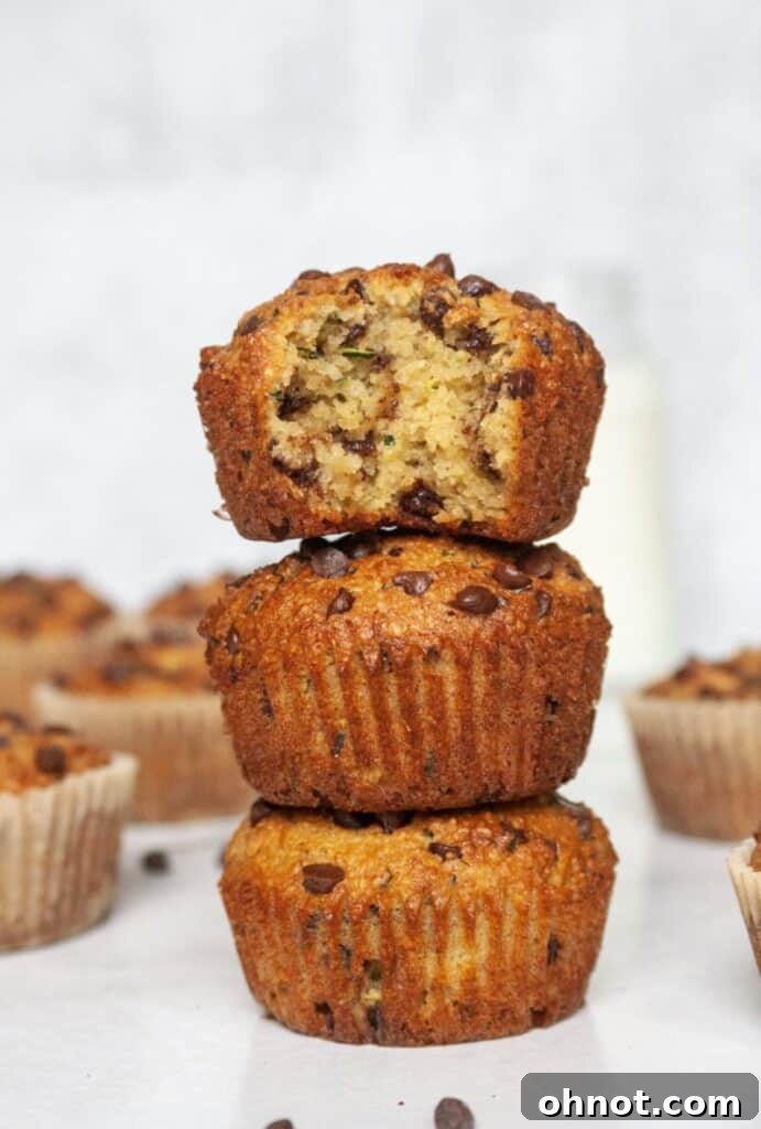 A stack of golden Paleo chocolate chip zucchini muffins, showing their delicious texture and chocolate chips.