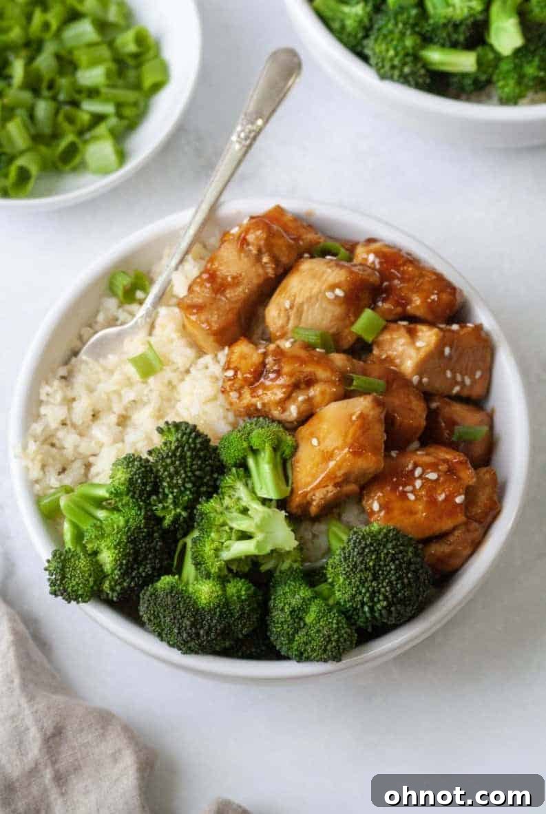 Delicious Whole30 Teriyaki Chicken served over cauliflower rice and broccoli, garnished with sesame seeds and green onions.