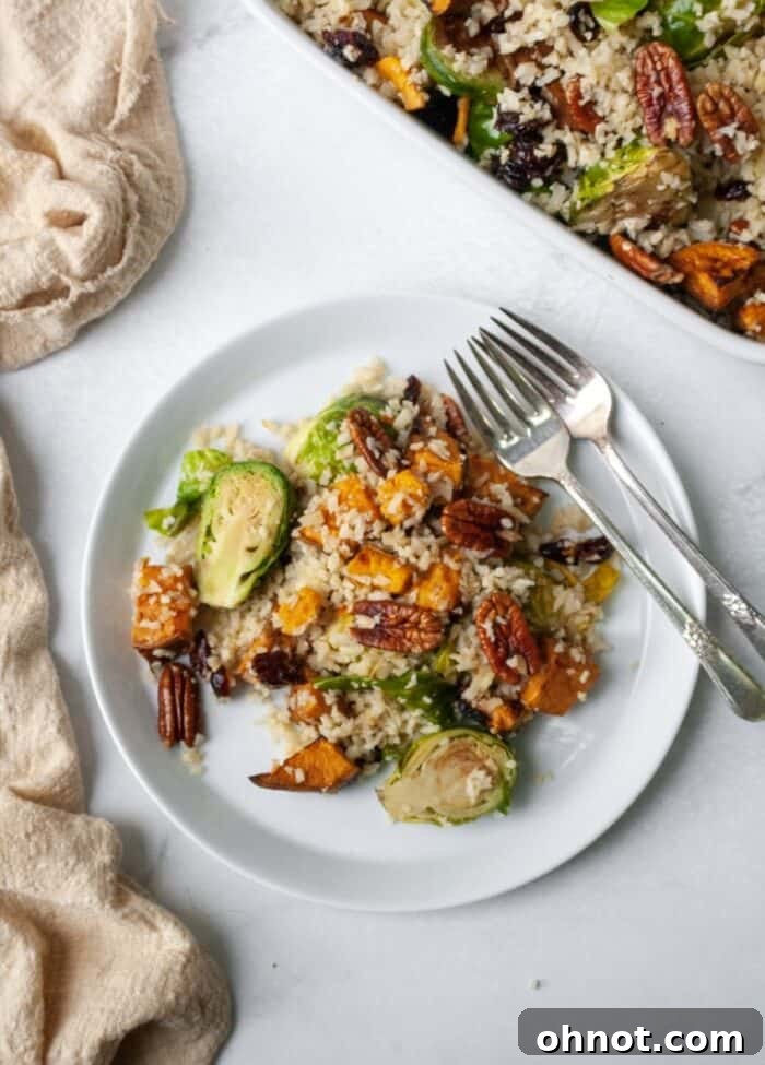 A serving of Paleo fall rice on a white plate, garnished with fresh herbs.
