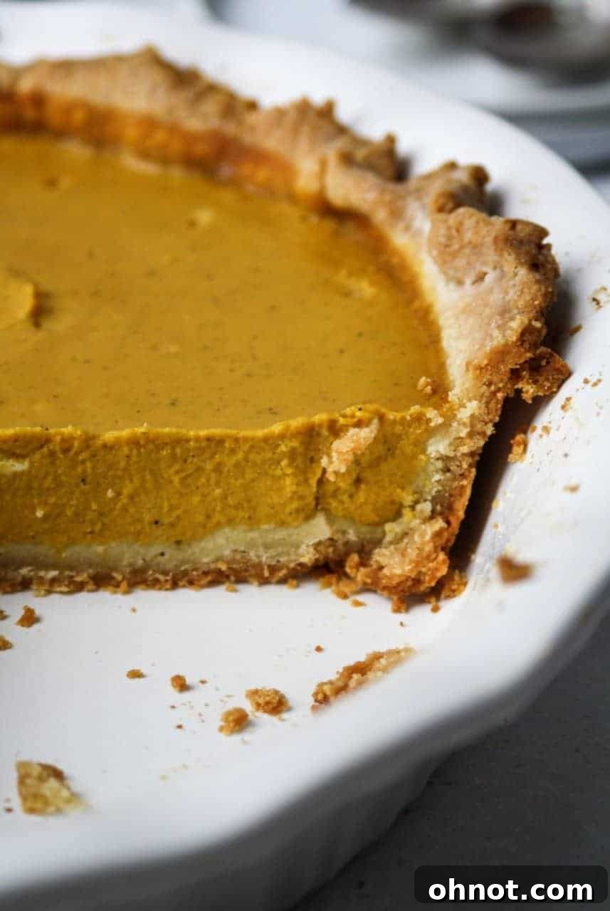 Close-up of the homemade Paleo pie crust being gently pressed into a pie dish.