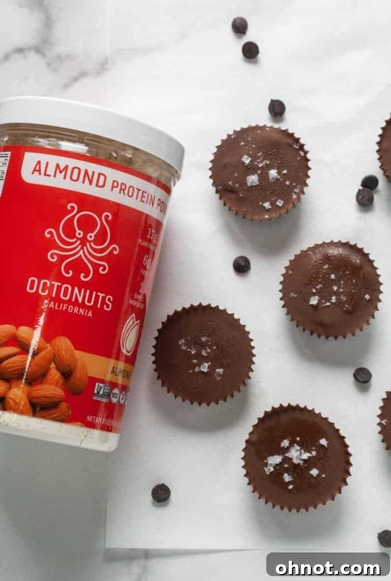 Four perfectly crafted pumpkin chocolate cups arranged neatly, showcasing their rich dark chocolate tops, vibrant orange filling, and appealing texture. They are ready to be served as a delightful and healthy no-bake dessert or snack.