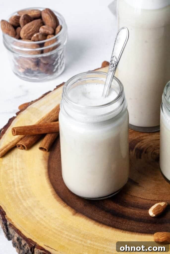 Freshly made Whole30 almond milk in a clear glass jar, ready for storage.