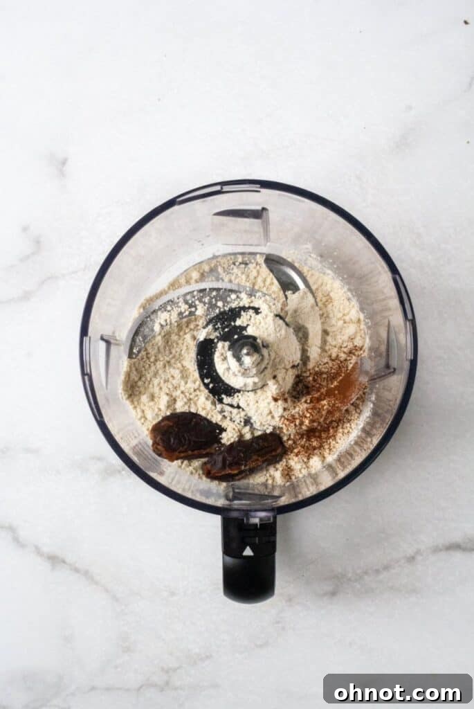Almond flour, water, dates, and cinnamon inside a Vitamix blender, ready to be processed for almond milk.