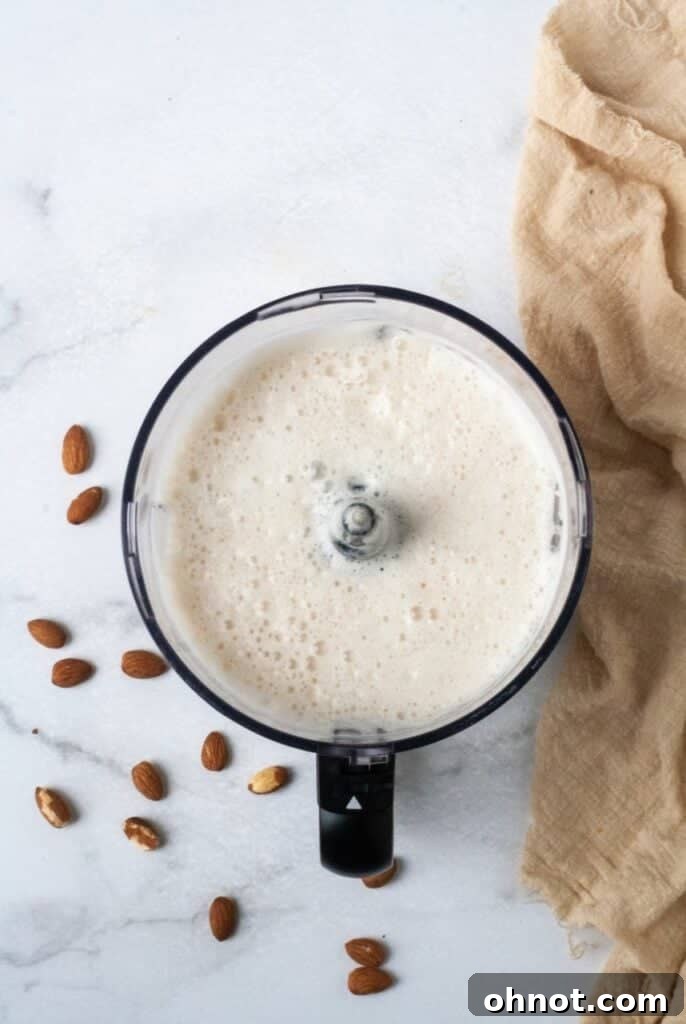 High-speed blender actively mixing ingredients to create creamy almond milk.
