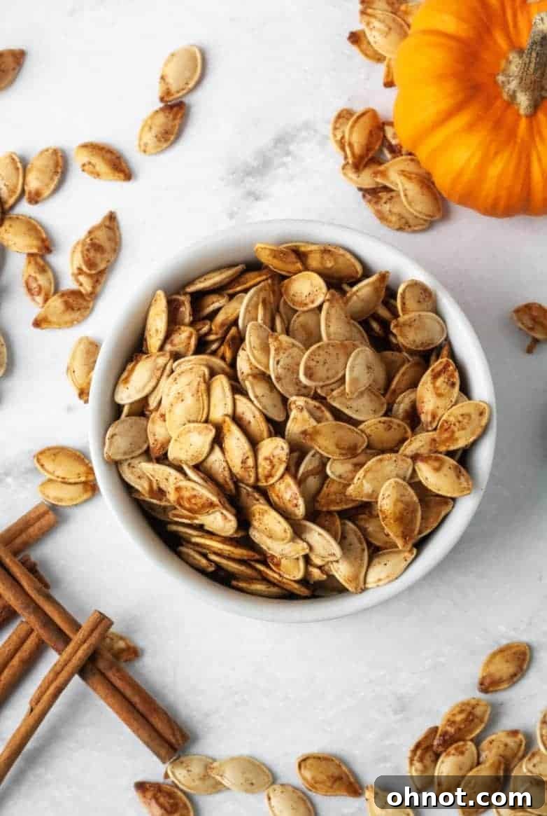 Golden brown, crispy homemade roasted pumpkin seeds scattered on a baking sheet, fresh from the oven.
