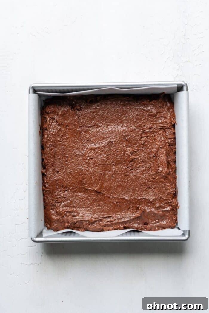 Baking pan with raw brownie batter spread evenly