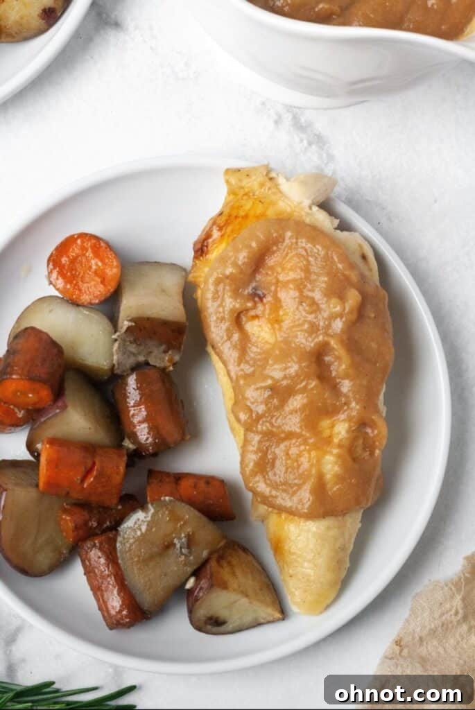 Roasted chicken with an assortment of vegetables, ready to be served with gravy.