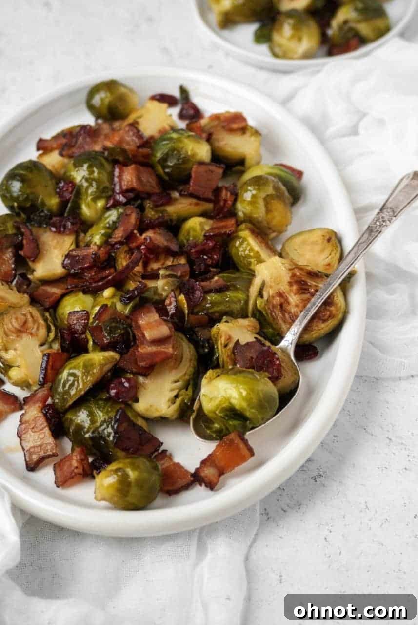 Delicious Maple Bacon Brussels Sprouts cooked in a skillet, ready to serve on a rustic wooden surface.