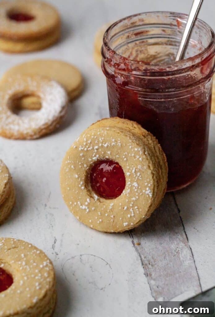 Gluten Free Linzer Cookies with Paleo strawberry jam, beautifully arranged on a white serving platter.