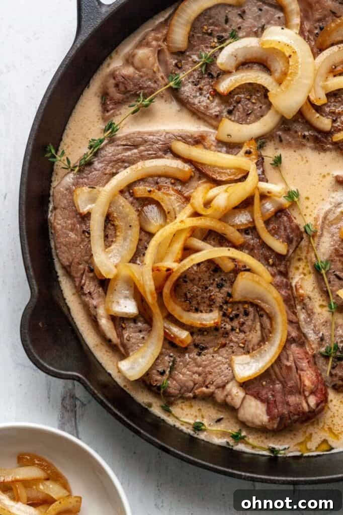 Whole30 Steak with Gravy served on a plate with mashed potatoes and fresh garnish