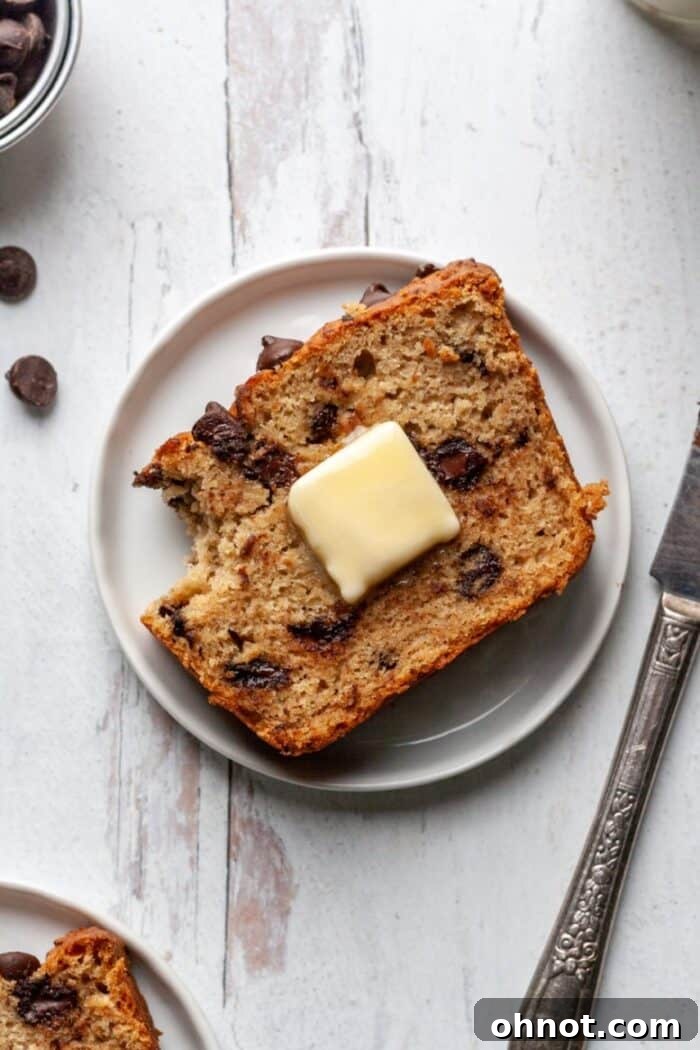 A piece of gluten free chocolate chip banana bread on a white plate.