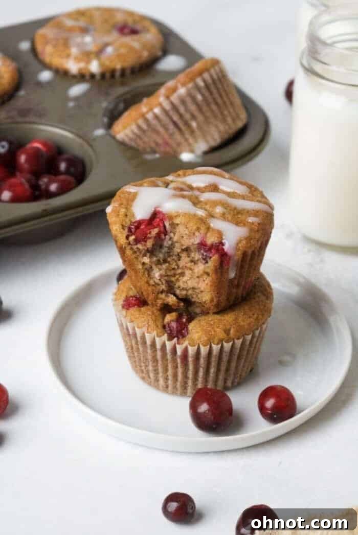 Paleo Orange Cranberry Muffins on a white plate with a glass of milk.