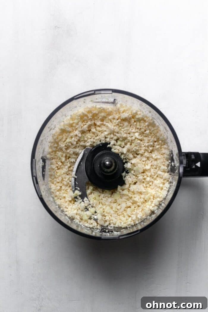 A food processor filled with riced cauliflower.