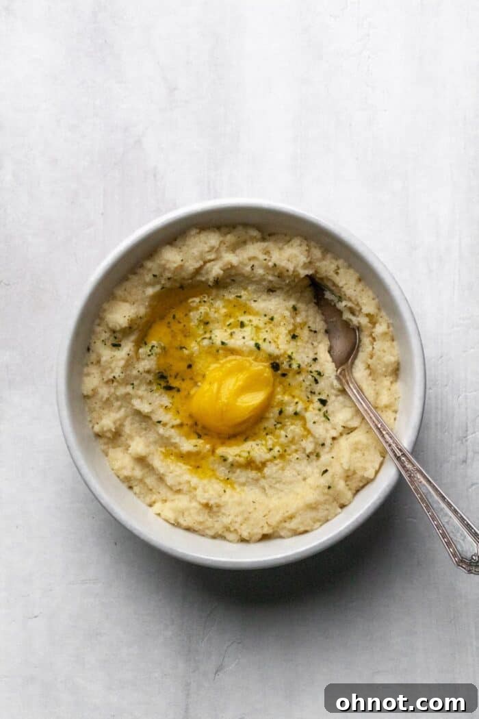 A white bowl filled with creamy Whole30 mashed cauliflower, ready to be served.