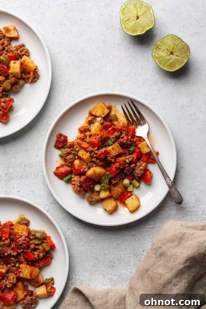 A beautifully arranged serving of Paleo Taco Skillet on a clean white plate, garnished with fresh cilantro and avocado slices, ready to be enjoyed.
