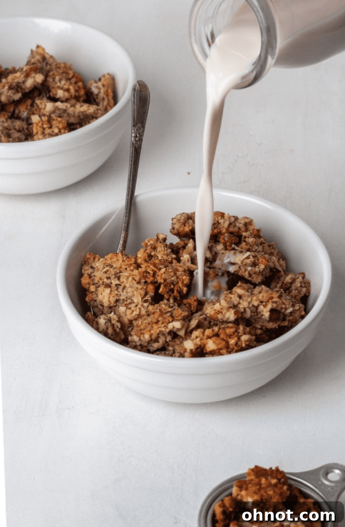 A bowl of chunky granola with almond milk.
