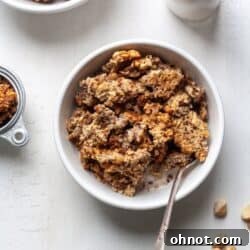 Chunky Homemade Granola with macadamia nuts in a white bowl with milk.