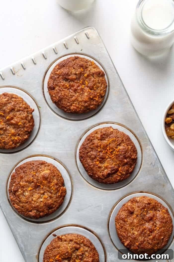 Paleo Morning Glory muffins baking in a silver muffin tray, filling the kitchen with a delightful aroma.