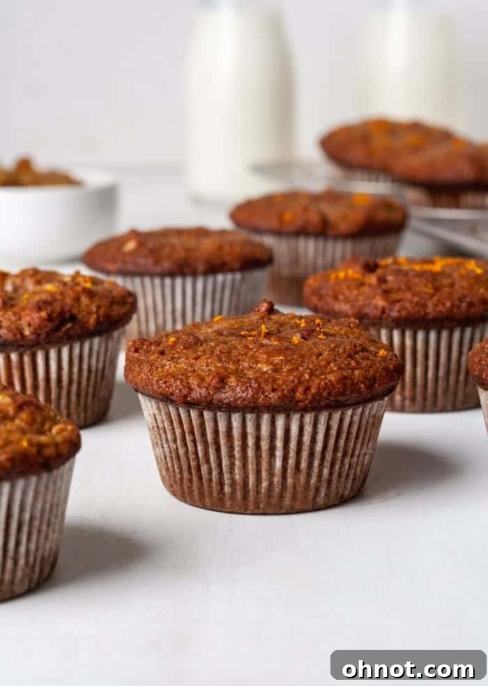 Paleo Morning Glory Muffins on a white backdrop with a glass of milk, invitingly presented.