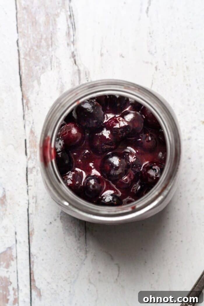 Freshly cooked Vegan jam being transferred into glass jars.
