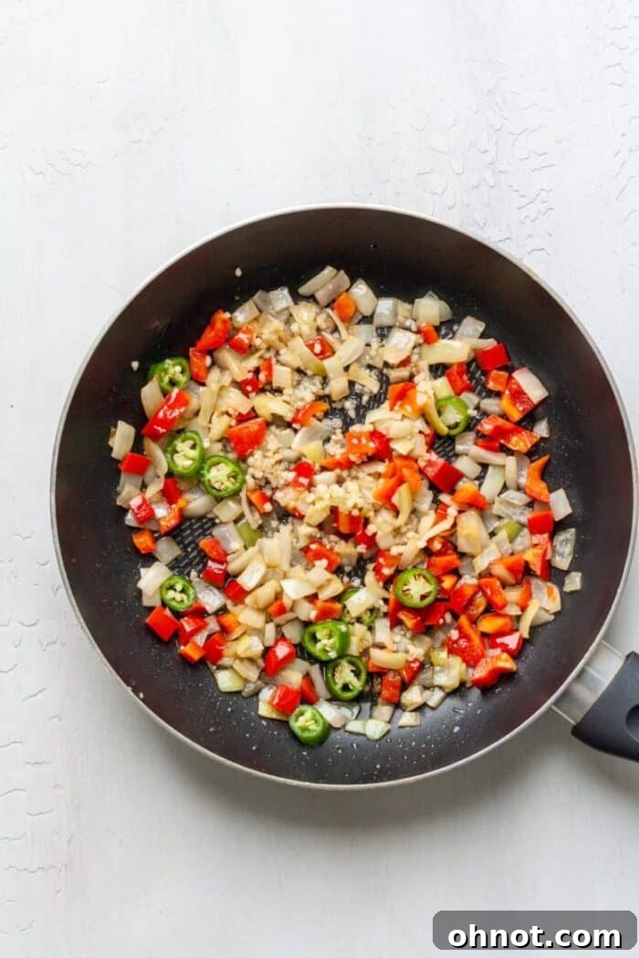 Onions, peppers and garlic in a black skillet.