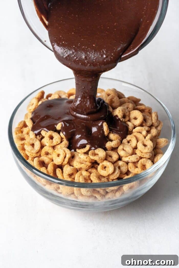 Paleo cereal with melted dark chocolate and almond butter being mixed in a bowl.