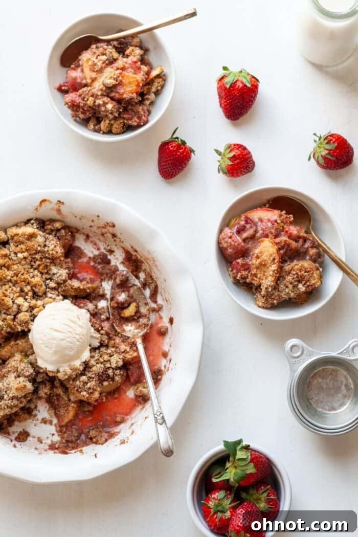 A beautifully presented gluten-free apple strawberry crumble on a pristine white backdrop, ready to be served.