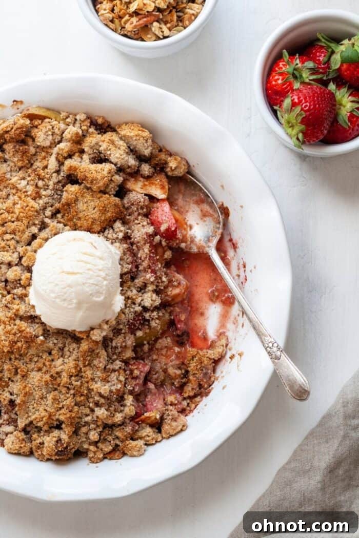 A full gluten-free apple crumble in a white pie plate, showcasing its golden topping and inviting texture.
