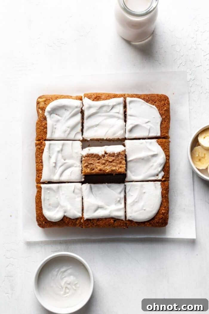 A gluten free banana cake on a white backdrop, elegantly frosted.