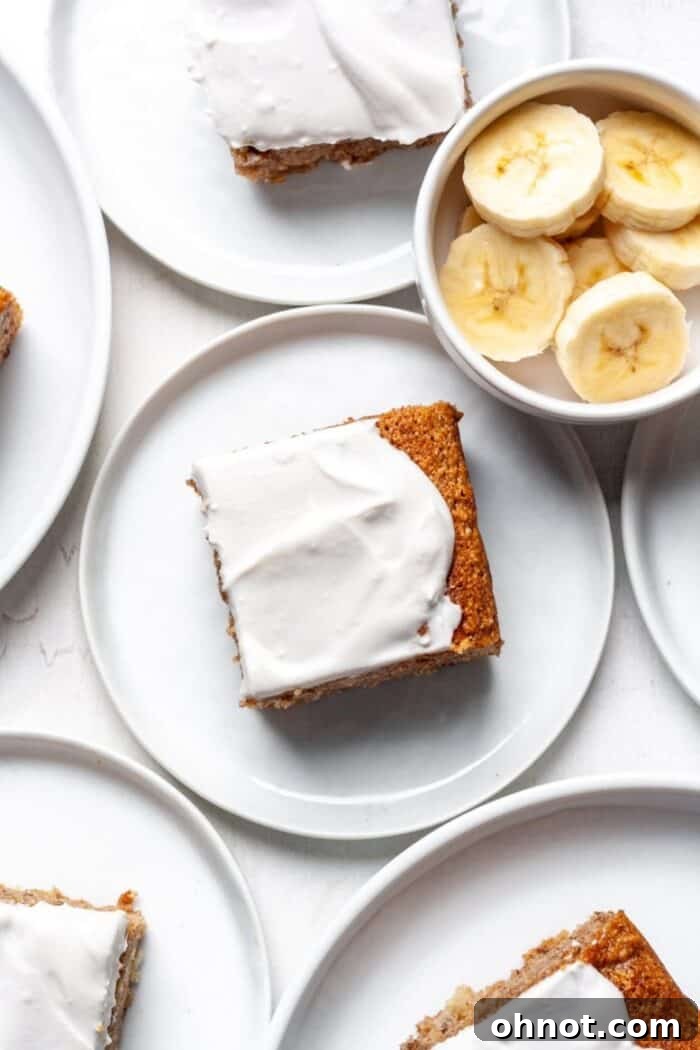 Almond flour banana cake with creamy vanilla frosting and a slice removed.