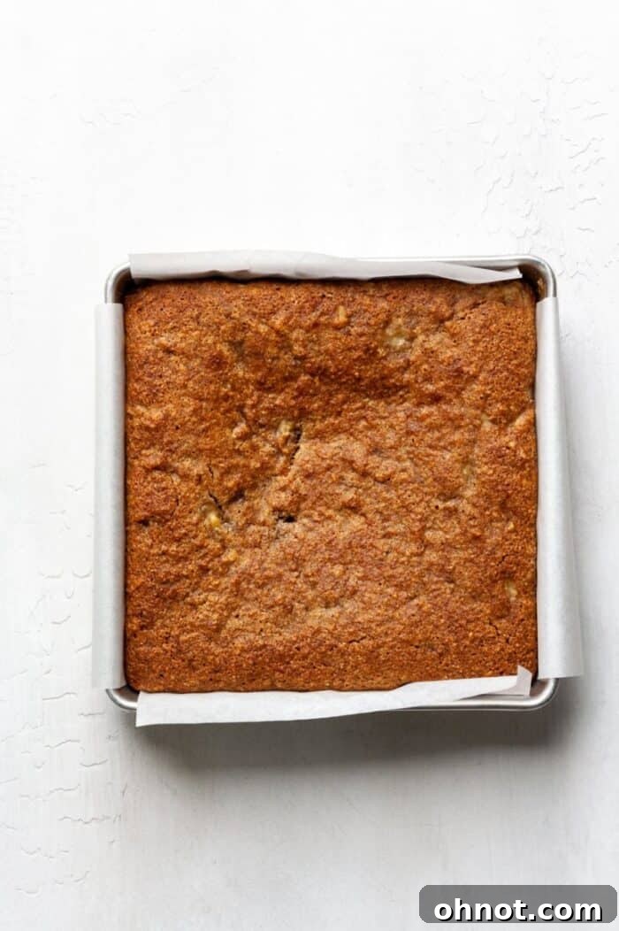 A baked gluten free banana cake resting in its baking pan to cool.