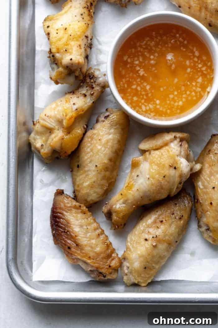 Air-fried chicken wings coated with a glistening honey garlic sauce in a mixing bowl.