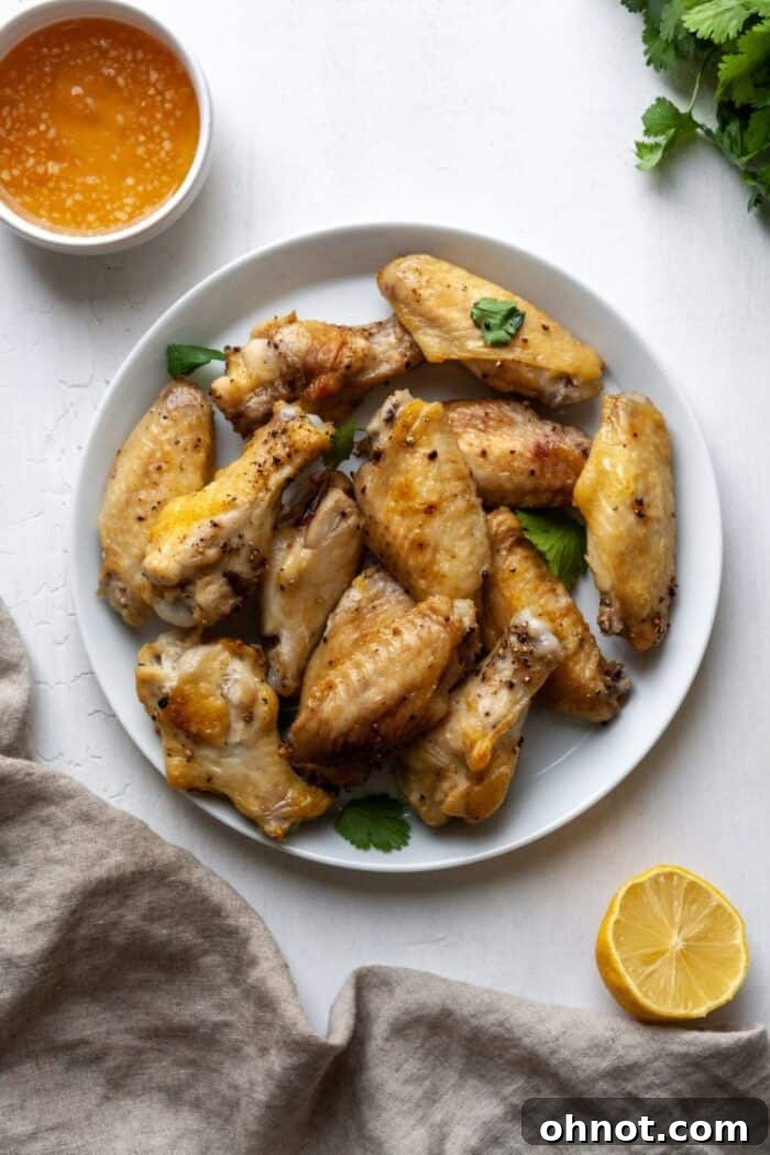 A close-up shot of golden-brown air-fried chicken wings, showing off their crispy texture.