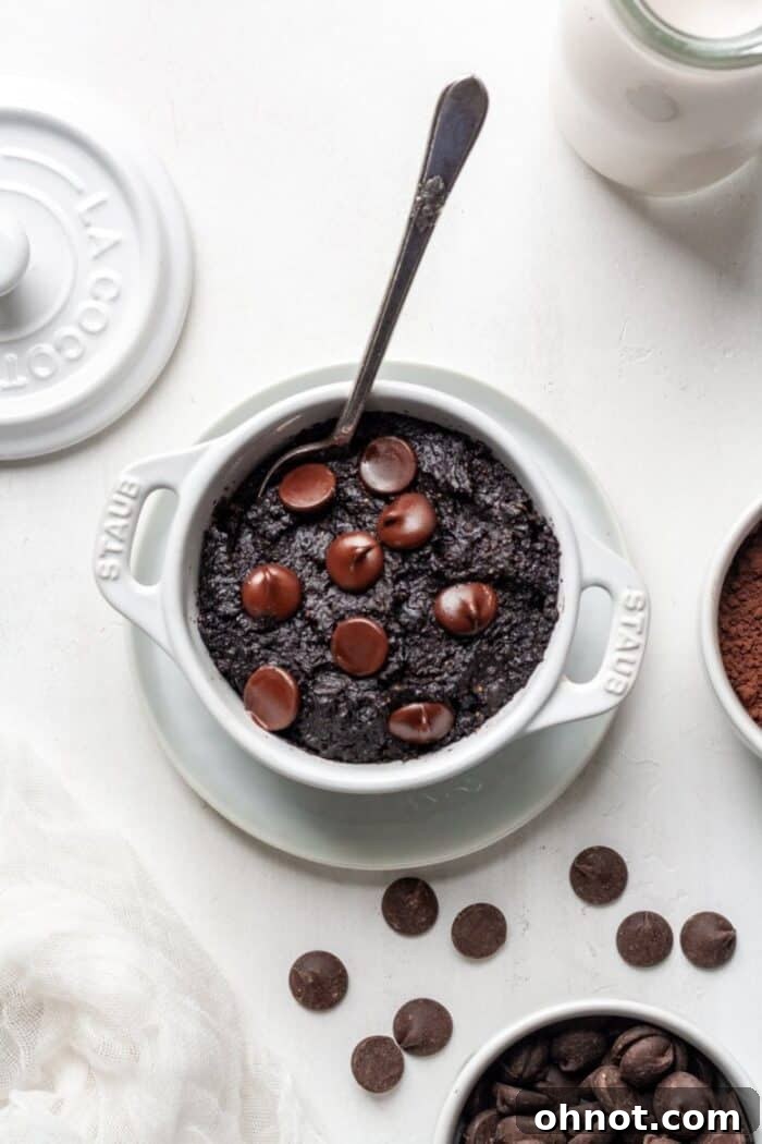 Vegan mug brownie in a white mug, perfectly baked and ready to eat.